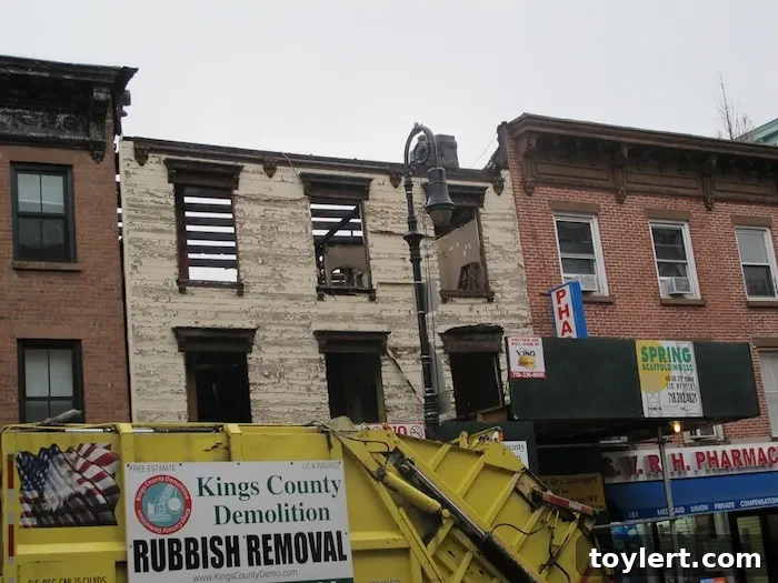 Demolition Begins for Smith Street Wooden House 2 Historic wood-clad house on Smith Street in Brooklyn undergoing demolition, showing scaffolding and construction work.