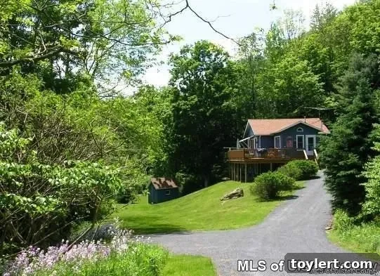 Upstate Cottages Where Charm Meets Expanse 3 Exterior view of a cozy Catskills cottage at 4 Robbins Road, Roxbury, highlighting its natural surroundings and potential for a private retreat