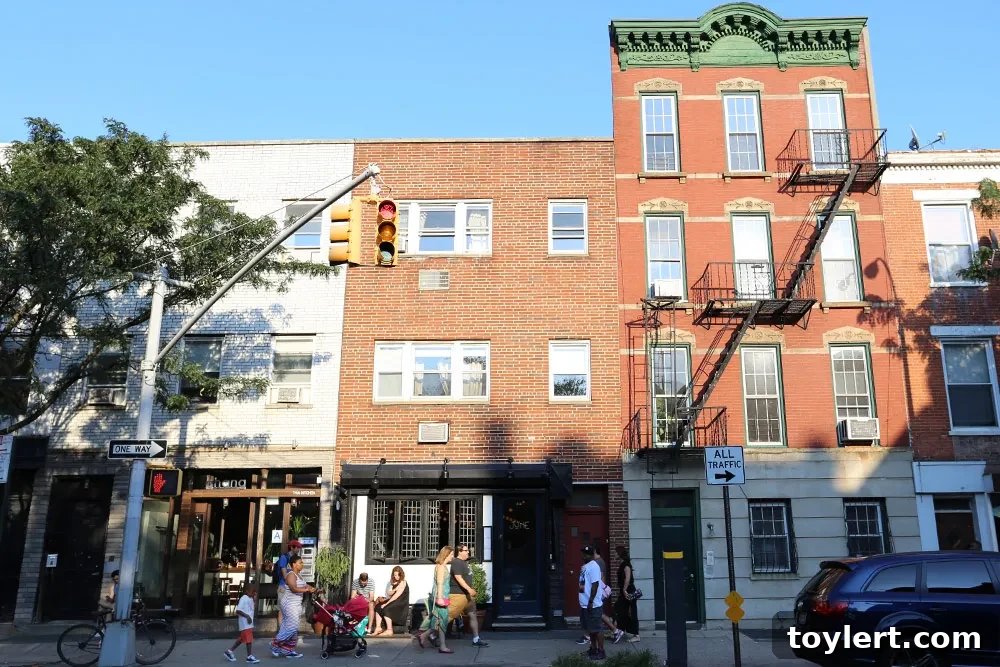 Thursday Links: Police Commissioner Further Discusses J'Ouvert 2 A picturesque view of Court Street in Cobble Hill, showcasing classic brownstone architecture and a vibrant street scene.