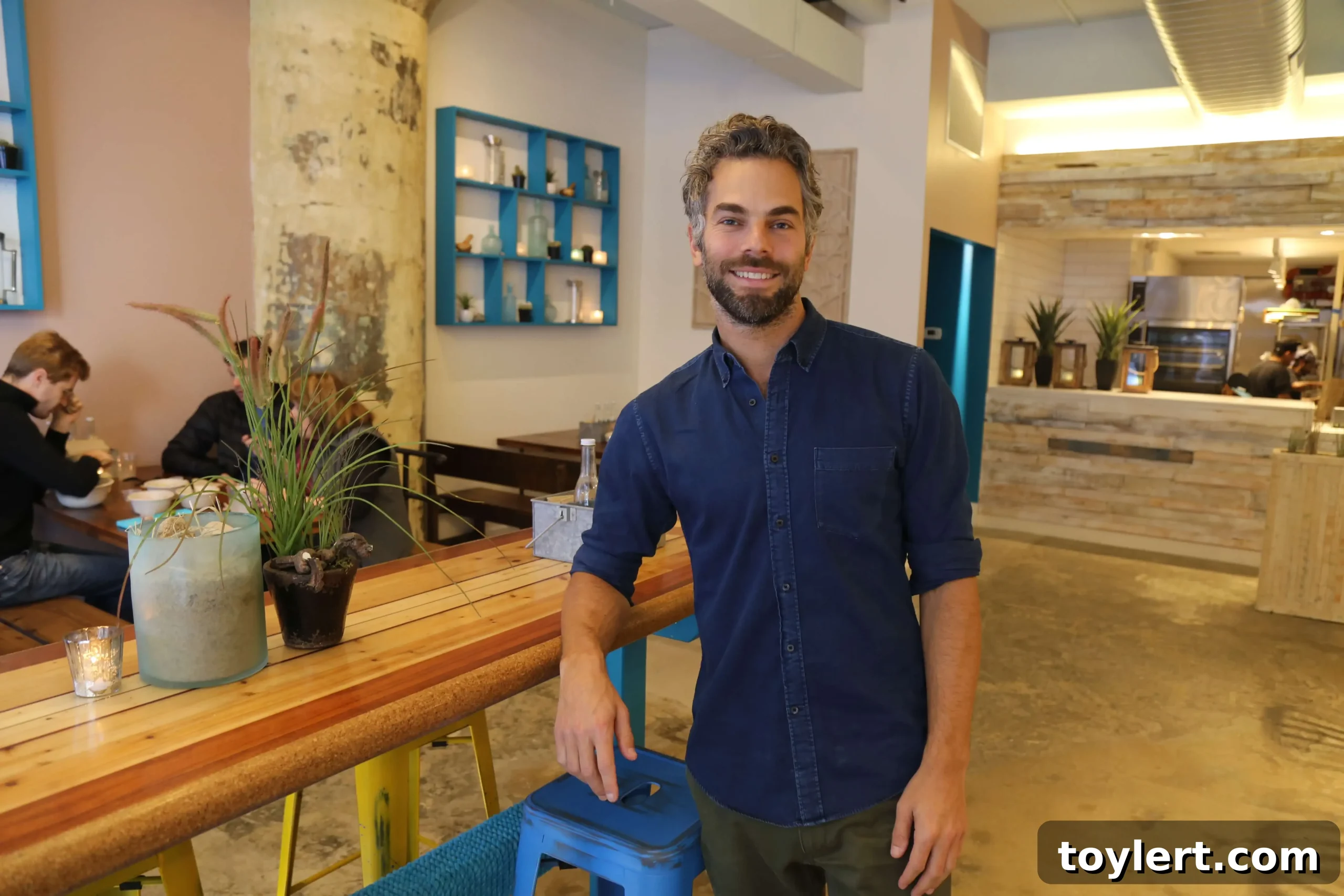 Taco Dumbo owner Brendan Hirsch. Photo by Sean Devlin. A vibrant, beach-inspired restaurant interior with warm lighting and colorful decor.