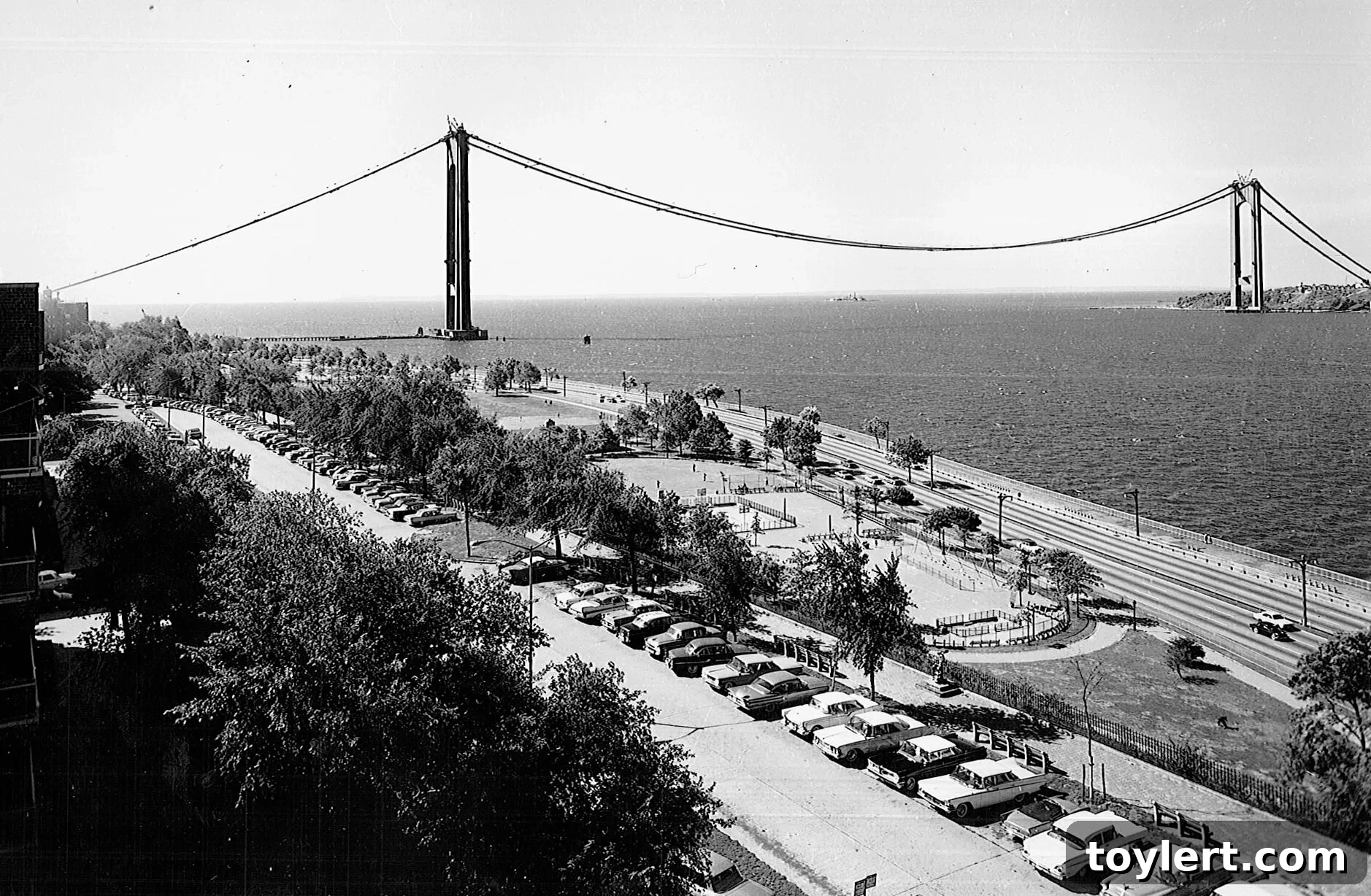 Early construction phase of the Verrazano-Narrows Bridge, showing initial tower structures rising from the water in the Narrows