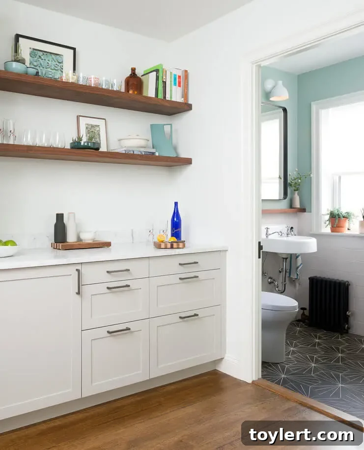 Chic, compact powder room design integrated seamlessly under a staircase in a brownstone parlor level renovation, featuring modern fixtures and classic finishes.