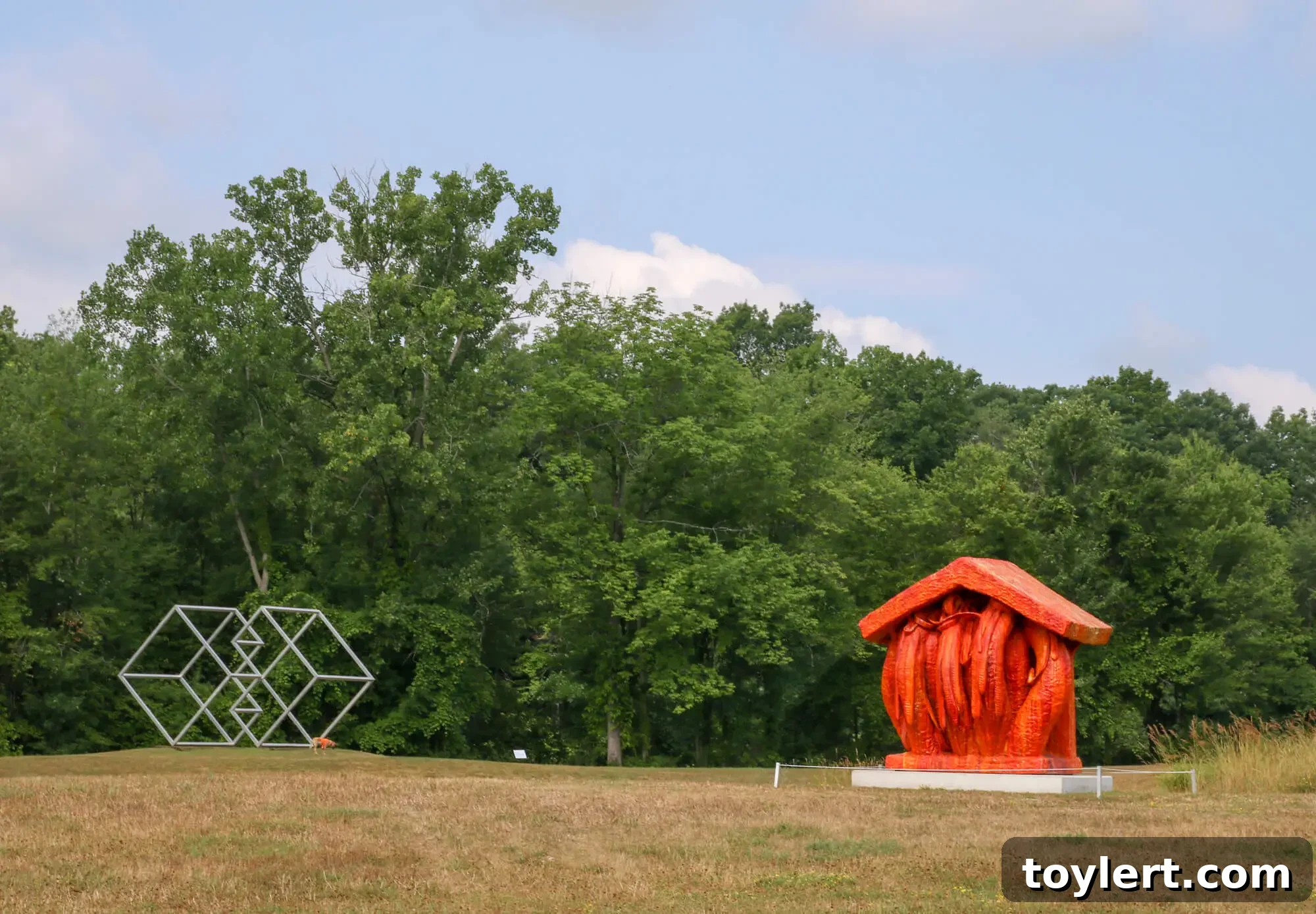 Art Omi outdoor sculpture park in Ghent, NY featuring contemporary art and natural landscapes. Iconic sculptures 'Valledor' by Forrest Myers and 'Pyre' by Matt Wedel are visible.