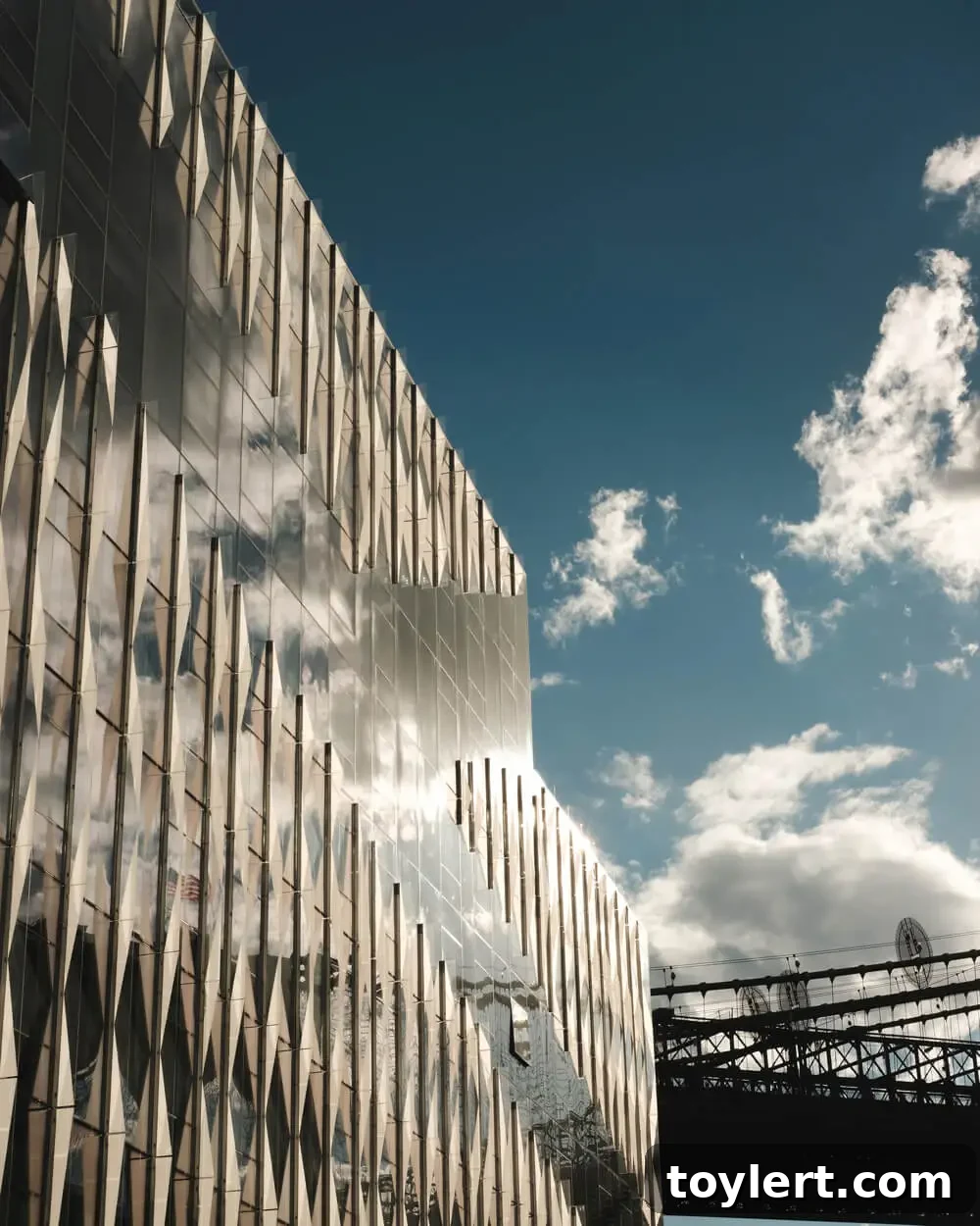 The striking glass facade of 60 Water Street in Dumbo, reflecting the surrounding urban landscape and sky.