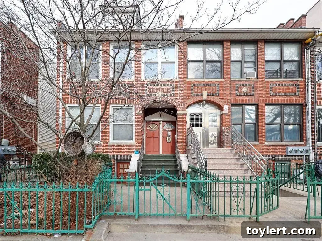 Exterior view of a historic two-family home in Sunset Park, Brooklyn, with tapestry brick and classical details