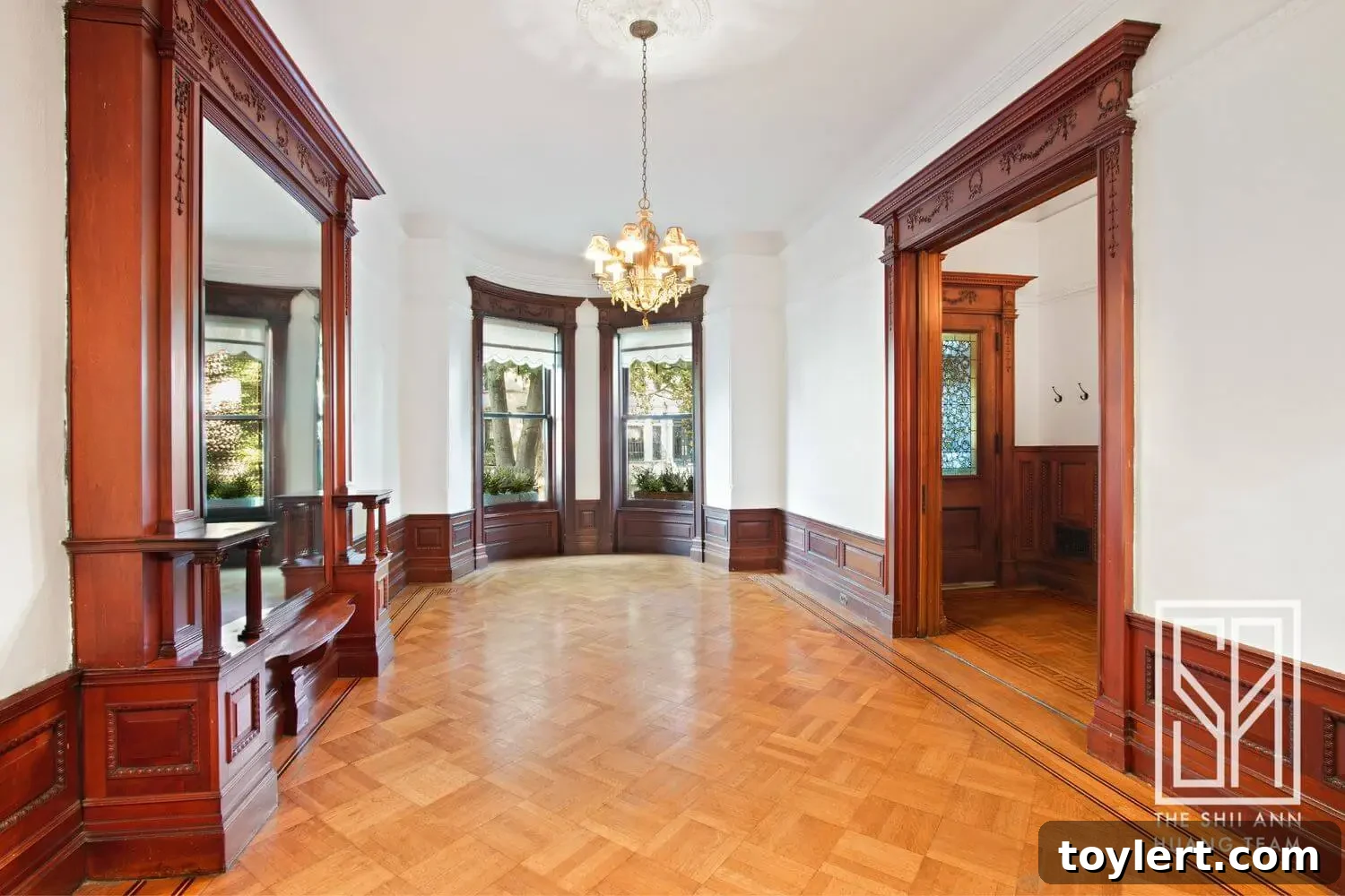 Stunning parlor with ornate woodwork and historic details in a Park Slope brownstone.