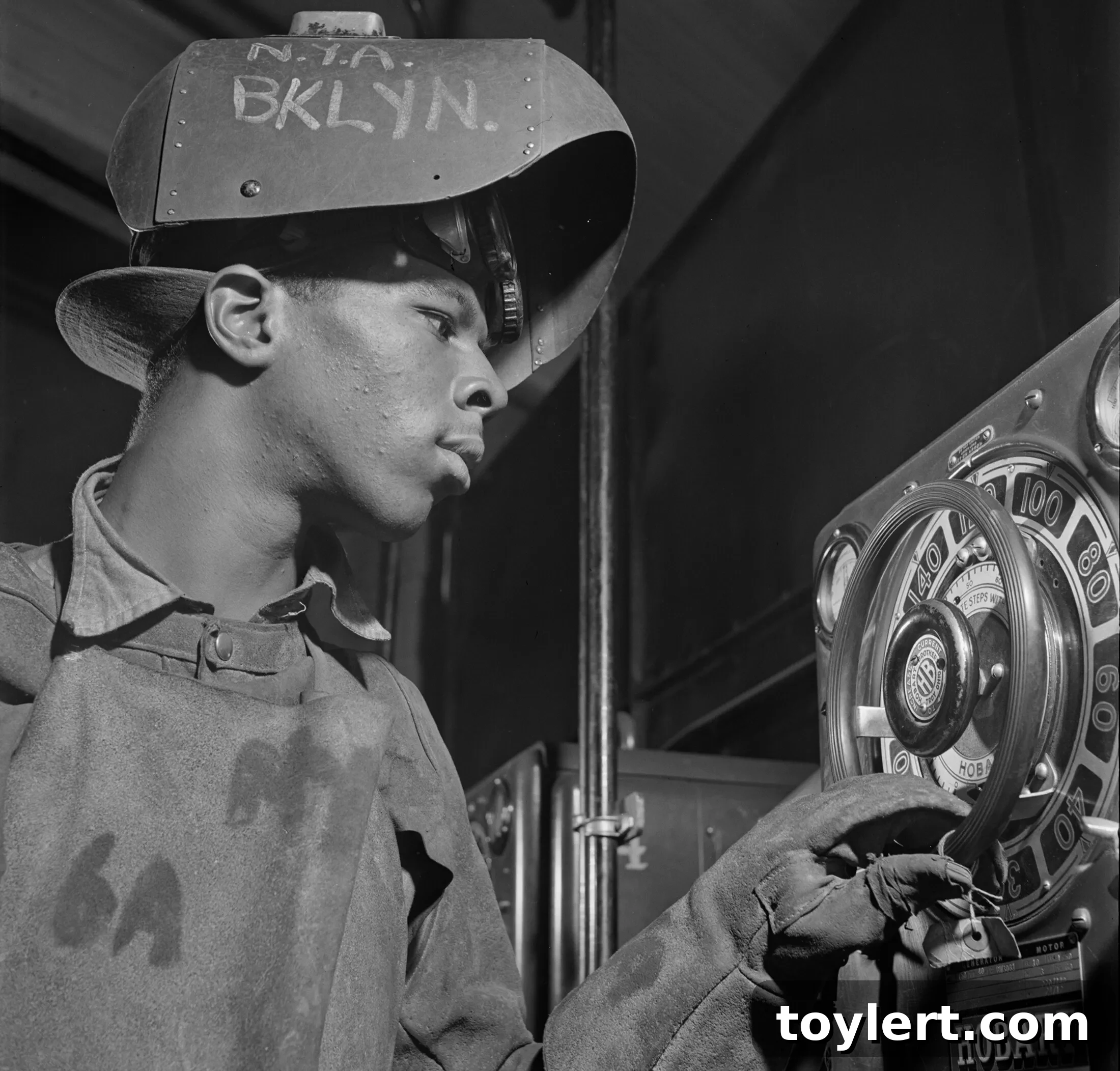 A young man wearing protective gear, diligently training to be a welder at a National Youth Administration work center in Brooklyn during 1942, reflecting wartime industrial effort.
