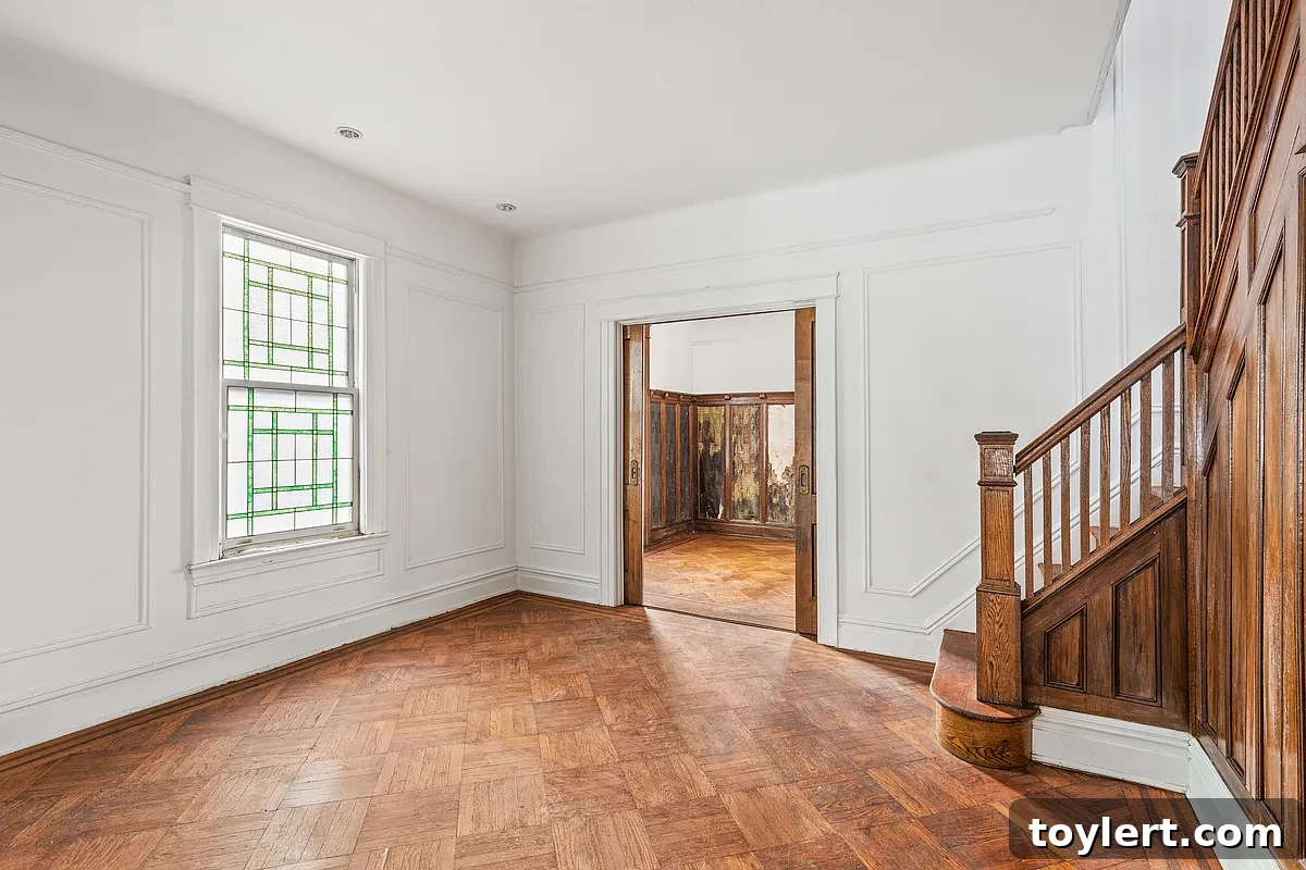 Inviting living room in a Brooklyn home, showcasing a classic original wood staircase as a focal point, emphasizing historic charm.